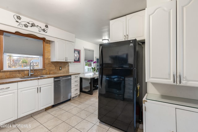 kitchen featuring black refrigerator, decorative backsplash, sink, dishwasher, and white cabinetry