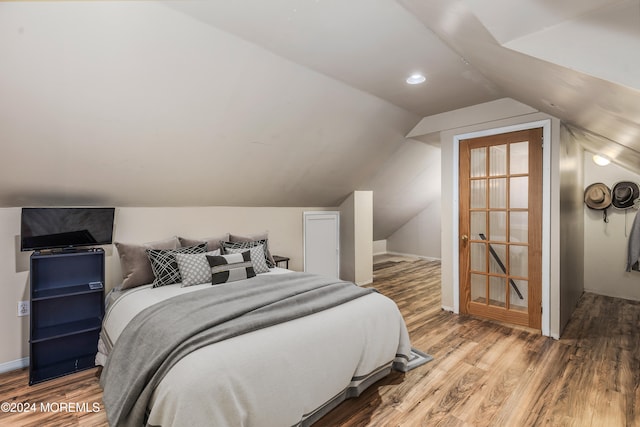 bedroom featuring wood-type flooring and lofted ceiling