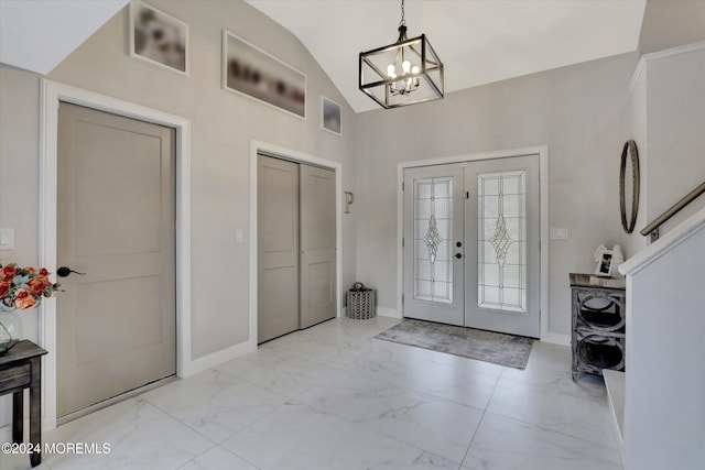 foyer with a notable chandelier, lofted ceiling, and french doors