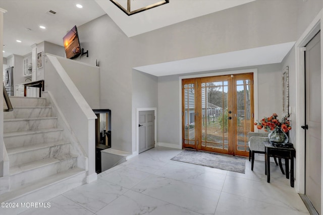 entryway featuring french doors and a towering ceiling