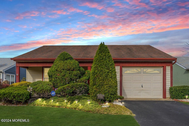 view of front of property with a garage and a yard