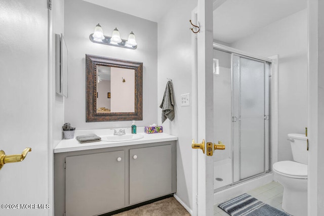 bathroom featuring tile patterned floors, a shower with door, vanity, and toilet