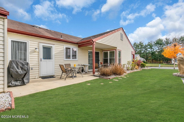 rear view of property featuring a yard and a patio