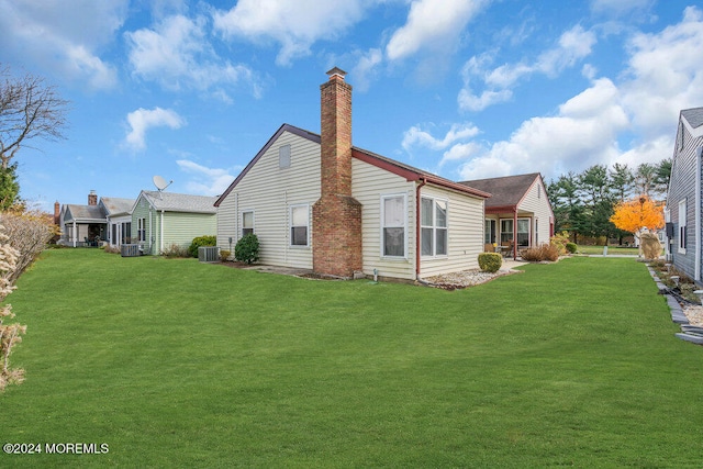 back of house with a yard and central AC