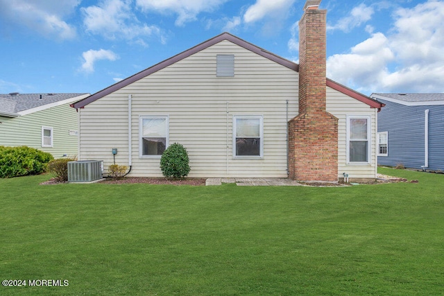 rear view of house featuring a lawn and central air condition unit