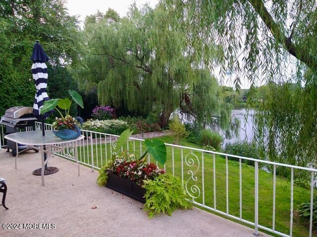 view of patio featuring a water view and area for grilling