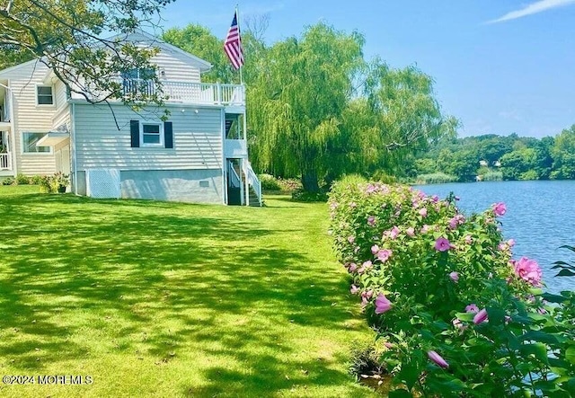 view of yard with a water view and a balcony