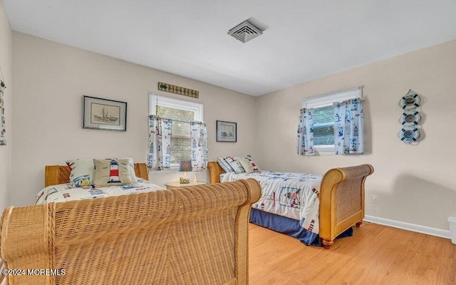 bedroom featuring hardwood / wood-style flooring and multiple windows