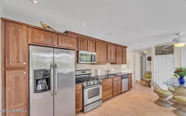 kitchen featuring backsplash, sink, ceiling fan, light tile patterned floors, and stainless steel appliances