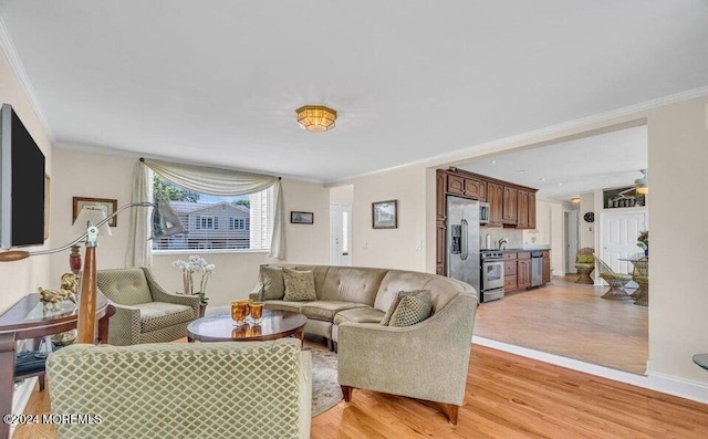 living room featuring light hardwood / wood-style flooring, ceiling fan, and crown molding