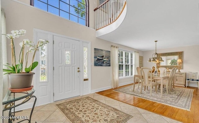 foyer entrance featuring a chandelier, a healthy amount of sunlight, and light wood-type flooring