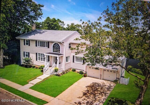 404 Ocean Rd, Spring Lake, NJ 07762 - colonial home featuring driveway, a front yard, a chimney, a garage, and a shingled roof