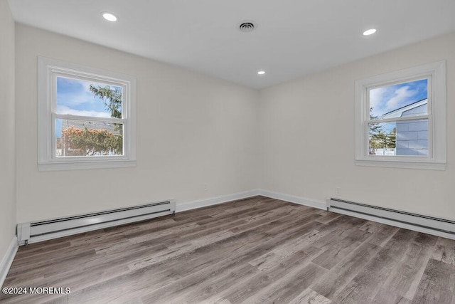 spare room with hardwood / wood-style flooring and baseboard heating