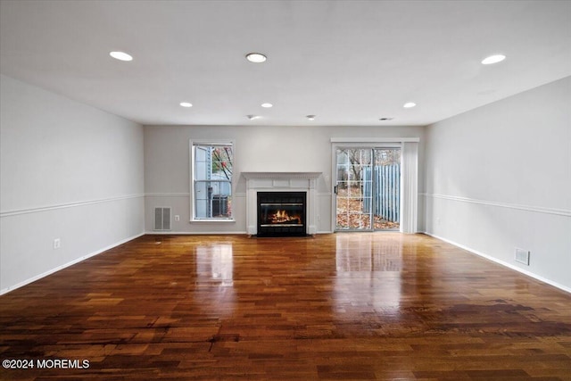 unfurnished living room featuring dark wood-type flooring and a wealth of natural light