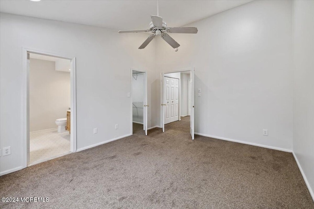 unfurnished bedroom featuring dark colored carpet, ceiling fan, and connected bathroom