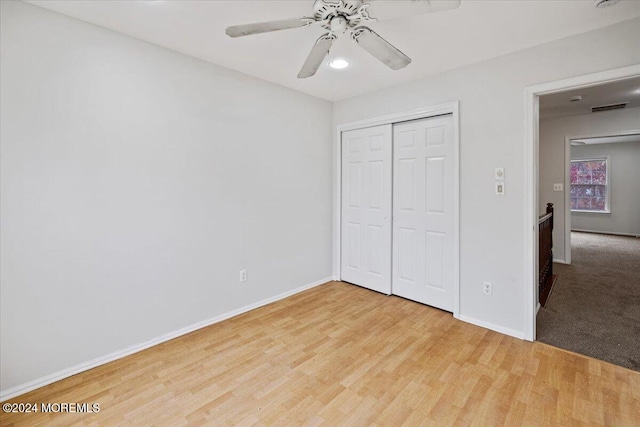 unfurnished bedroom featuring a closet, light hardwood / wood-style flooring, and ceiling fan