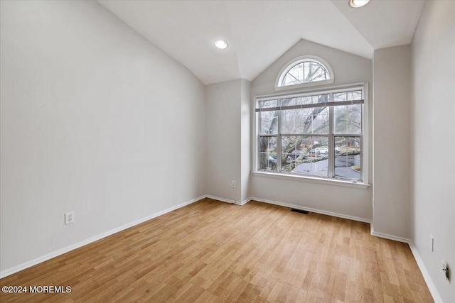 empty room featuring light hardwood / wood-style floors and vaulted ceiling