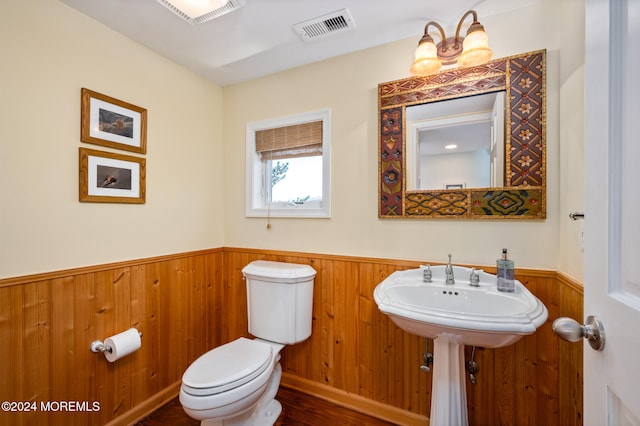 bathroom featuring wood walls, toilet, and wood-type flooring