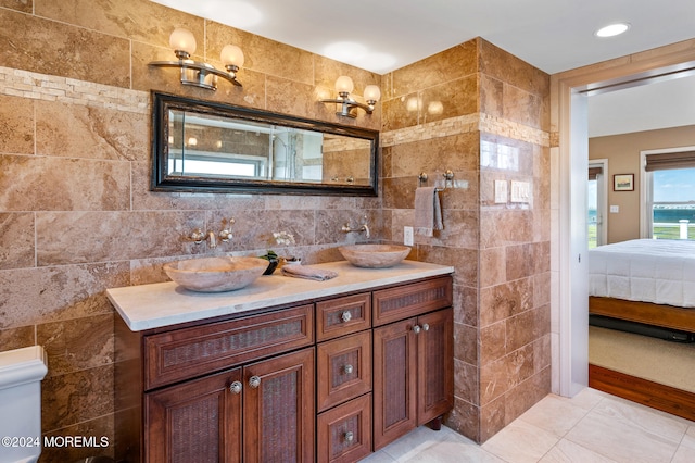 bathroom with vanity, tile walls, and toilet