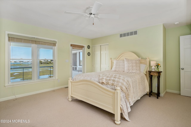 carpeted bedroom featuring ceiling fan and a closet