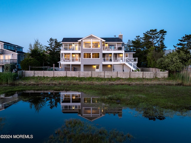 back house at dusk with a water view