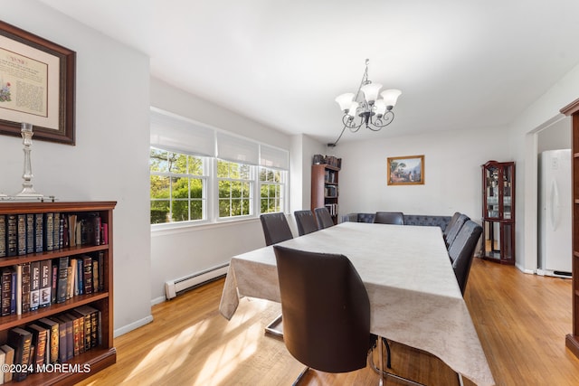 dining area with a baseboard radiator, an inviting chandelier, and light hardwood / wood-style floors