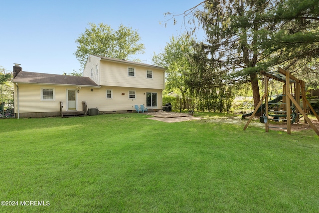 back of property with a playground, a yard, and cooling unit