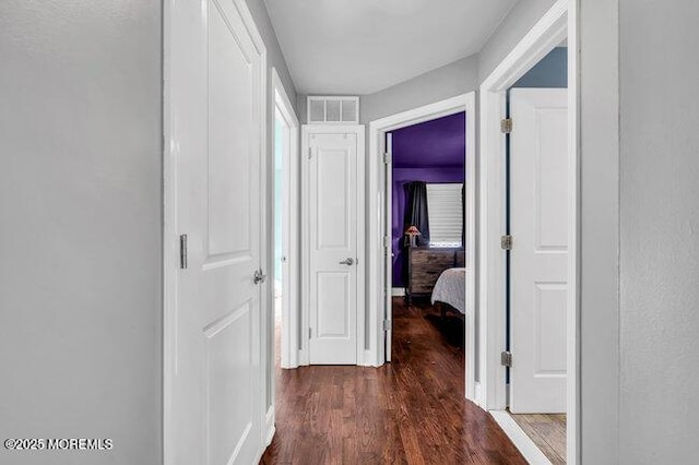 corridor with dark hardwood / wood-style flooring