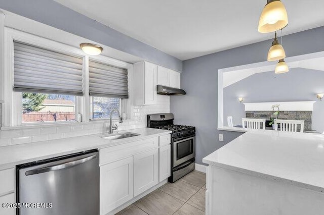 kitchen with pendant lighting, white cabinetry, stainless steel appliances, sink, and light tile patterned floors