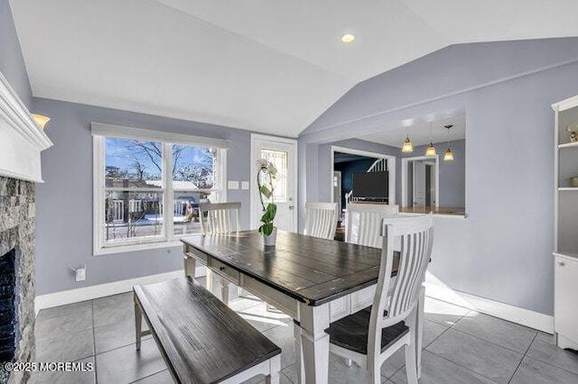 dining room with lofted ceiling and tile patterned floors