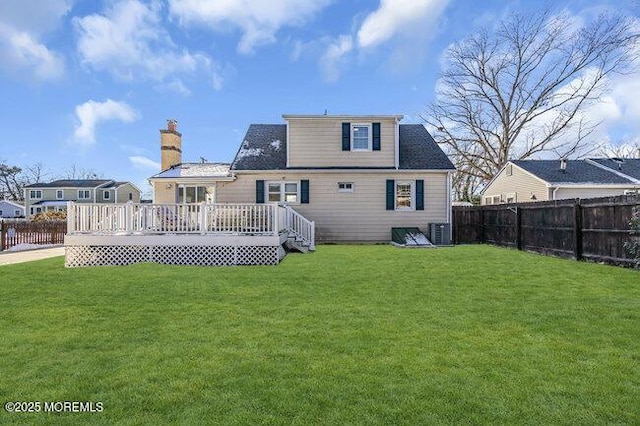 rear view of property featuring central AC unit, a wooden deck, and a lawn