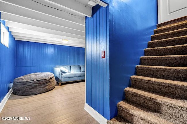 staircase featuring hardwood / wood-style floors and wood walls