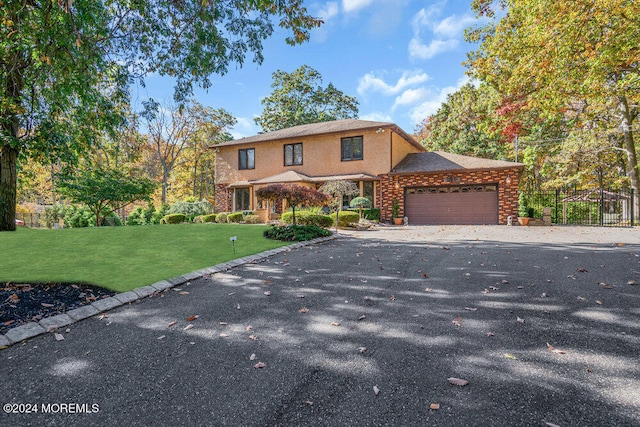 view of property featuring a garage and a front lawn