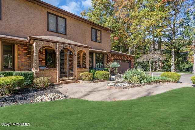 back of property featuring covered porch, a garage, and a yard