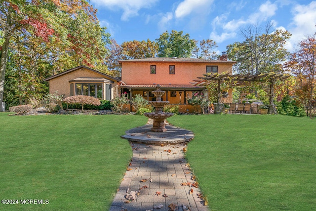 back of property with a yard and a pergola