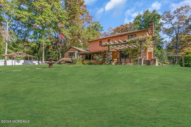 view of front of home with a front yard and a pergola