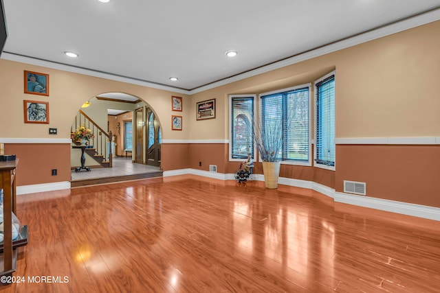 workout room featuring light hardwood / wood-style floors and ornamental molding