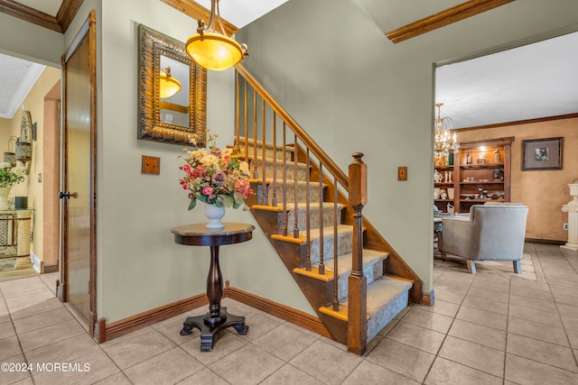 stairway with tile patterned floors, a notable chandelier, and ornamental molding