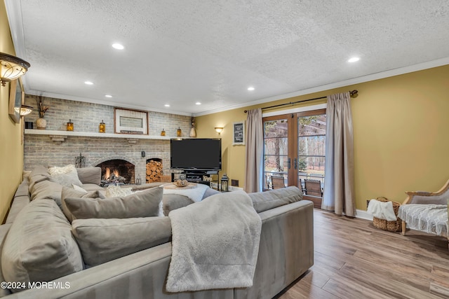 living room with a fireplace, hardwood / wood-style floors, a textured ceiling, and french doors