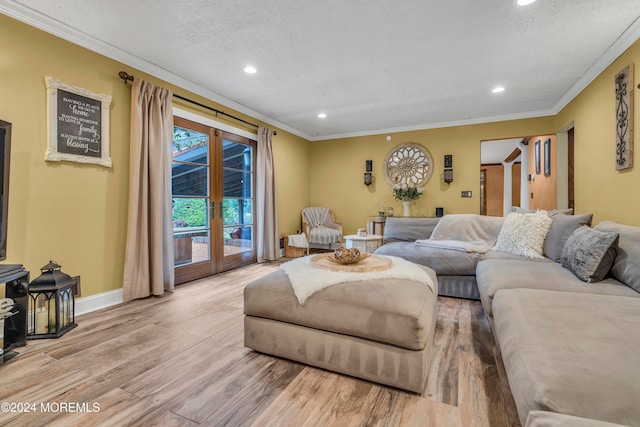 living room featuring a textured ceiling, crown molding, light hardwood / wood-style flooring, and french doors