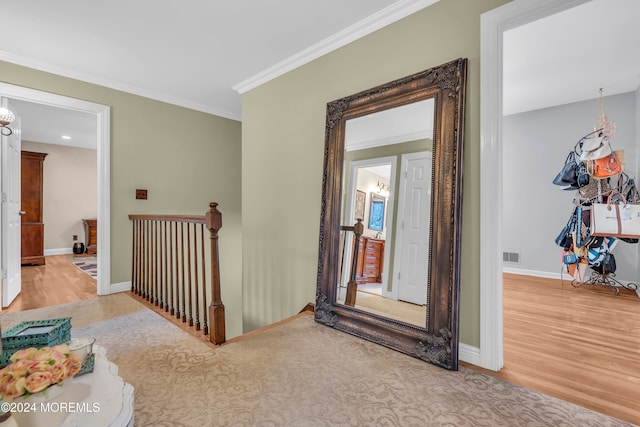 hallway with light hardwood / wood-style floors and ornamental molding