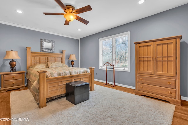 bedroom with light wood-type flooring, ceiling fan, and ornamental molding