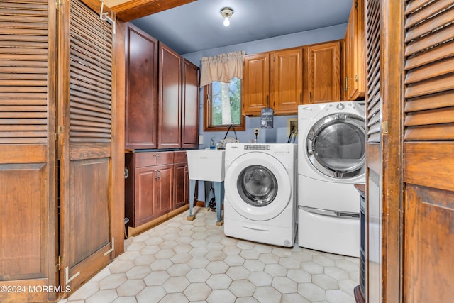 laundry room featuring washing machine and clothes dryer and cabinets