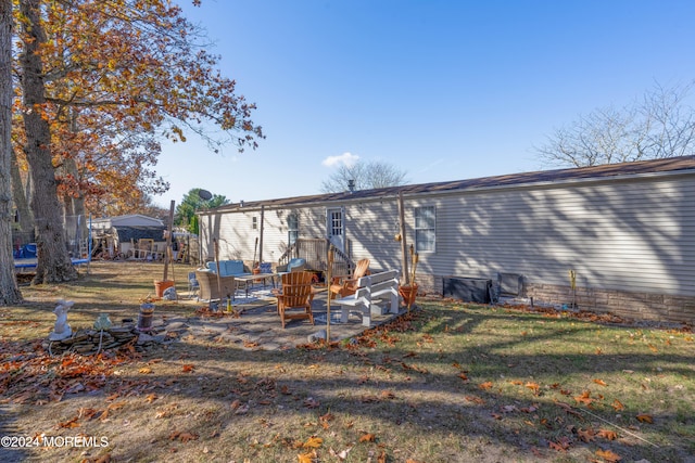 back of property with a lawn and a patio area