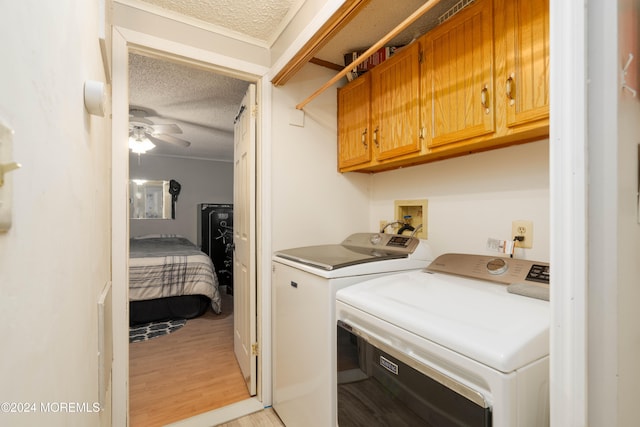 washroom featuring cabinets, ceiling fan, light wood-type flooring, a textured ceiling, and washing machine and clothes dryer