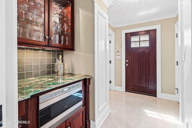 tiled entryway with bar and ornamental molding