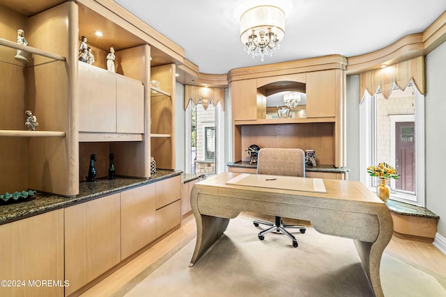 office area with light hardwood / wood-style floors and an inviting chandelier