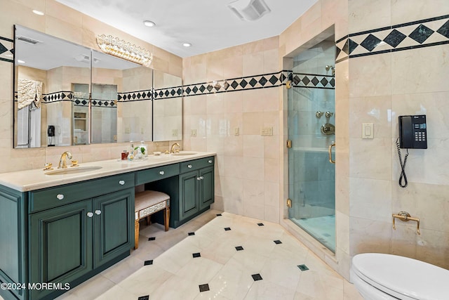 bathroom with vanity, toilet, tile walls, and walk in shower