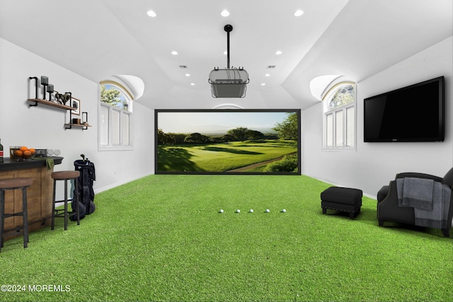 interior space with carpet, vaulted ceiling, and golf simulator