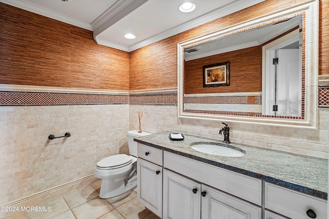 bathroom with tile patterned floors, toilet, vanity, tile walls, and ornamental molding